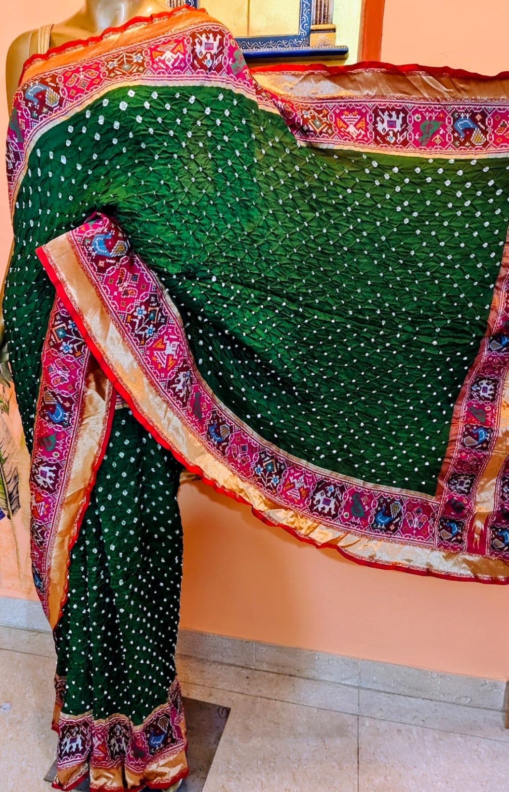 Parrot-green saree with a figured border, on a stand