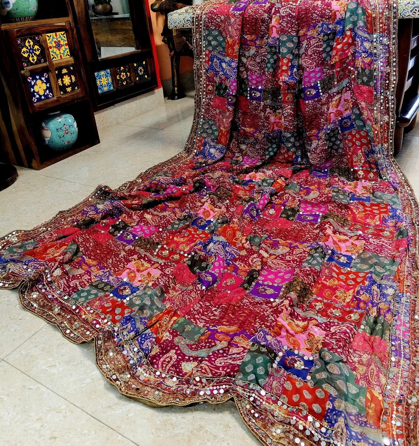 Multicolour patchwork saree with a mirror-work border, laid out