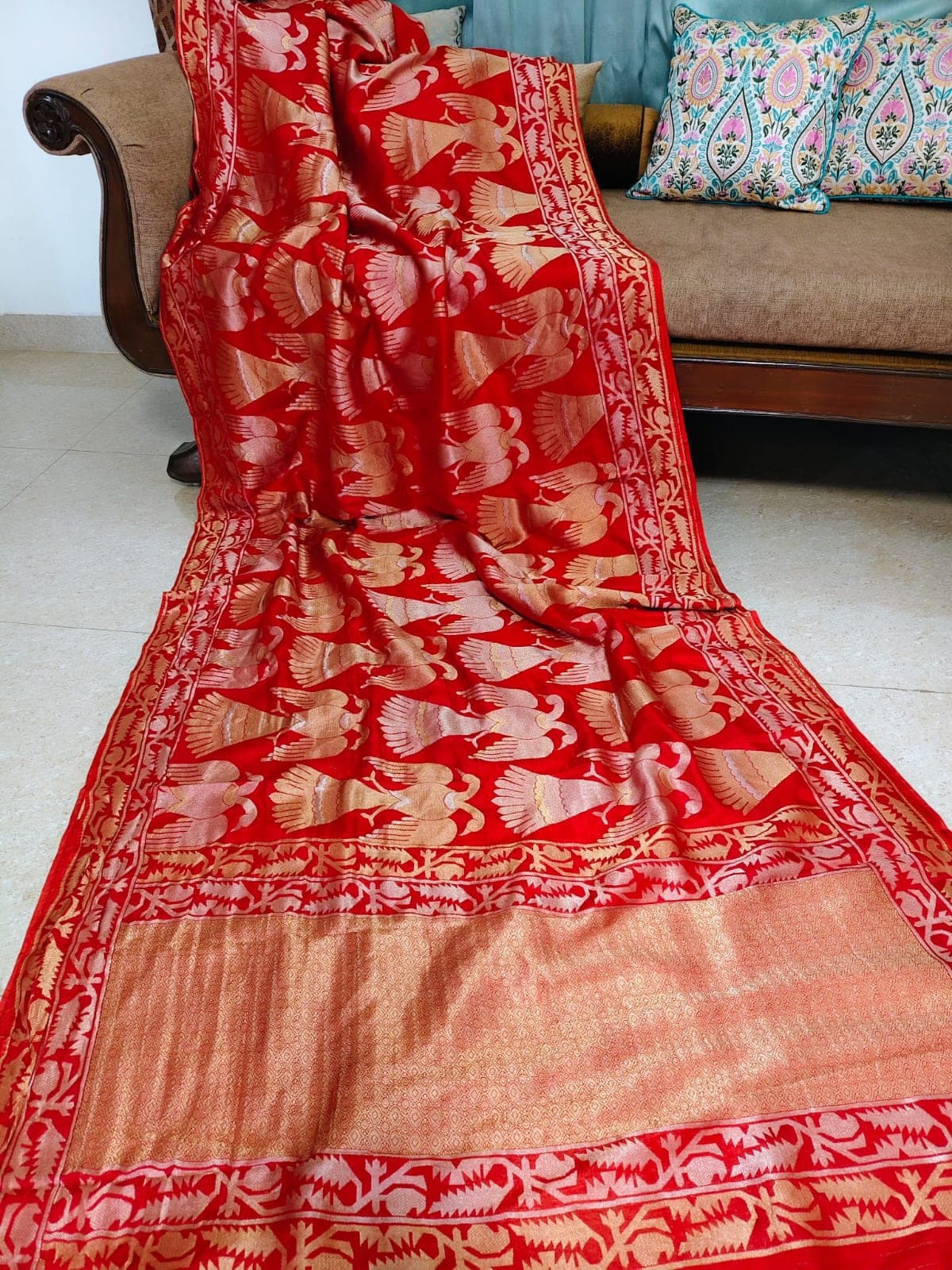 Red saree with bird motifs, laid out full length