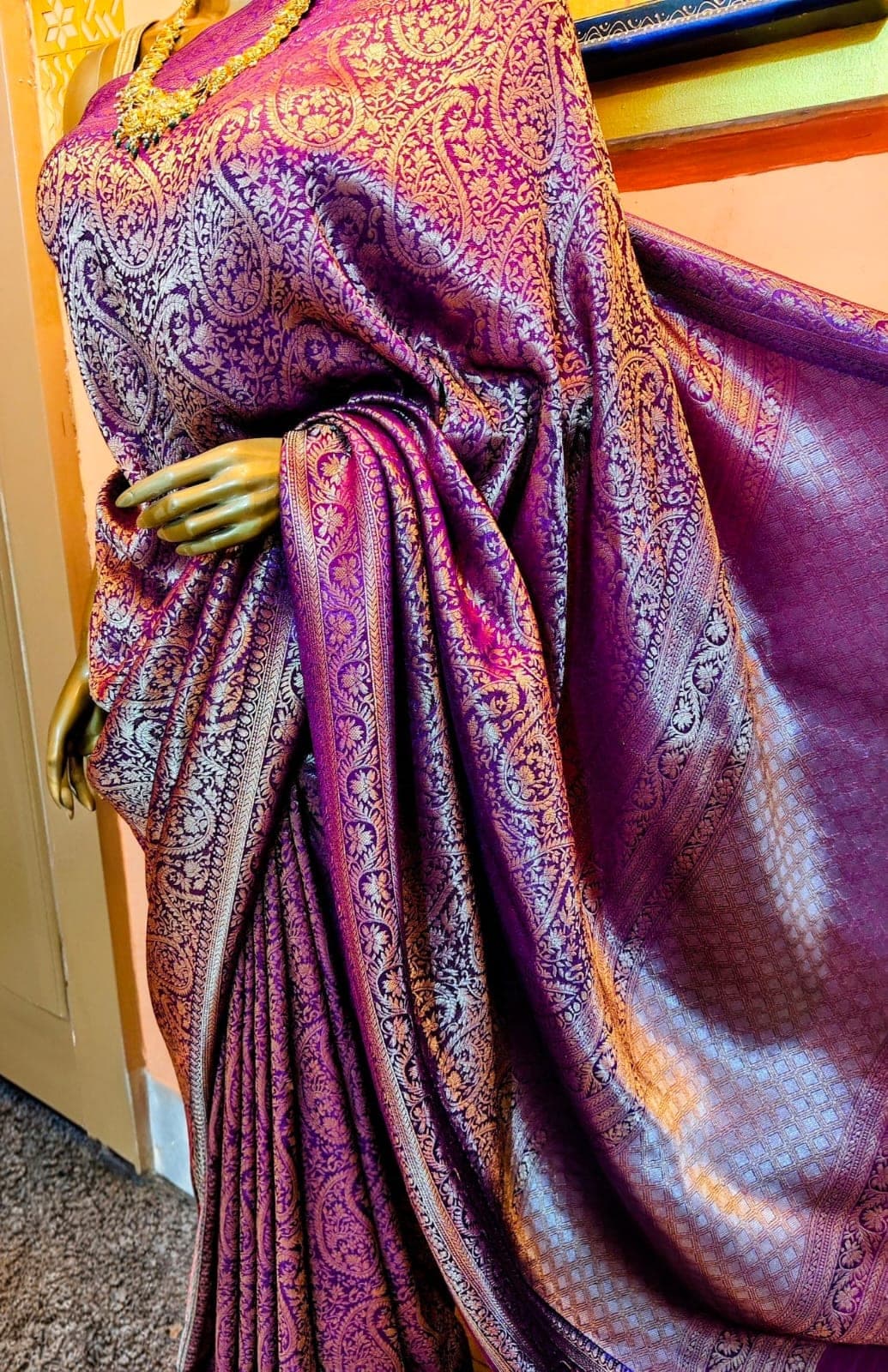 A purple silk saree draped in the showroom