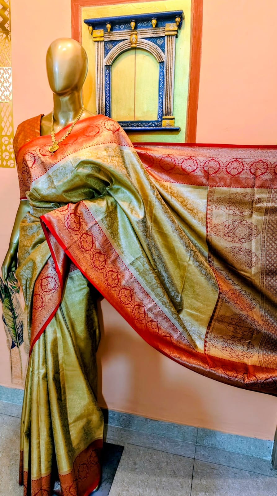 Antique gold saree with a red-gold Benarasi border and pallu, draped on a stand