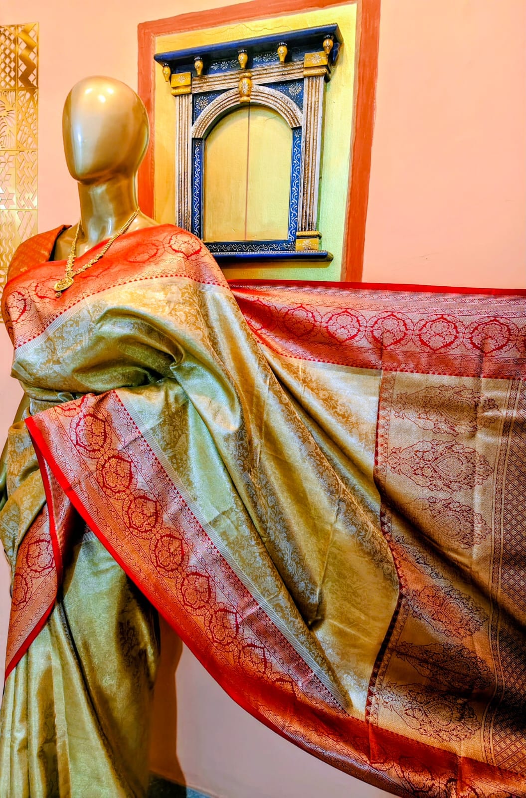 Antique-gold Kanjivaram saree draped on a stand